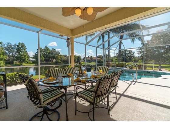 Dining alfresco under cover with ceiling fan enjoying fantastic views listening to your favorite music with outdoor speakers. - Single Family Home for sale at 6521 Sundew Ct, Lakewood Ranch, FL 34202 - MLS Number is A4514104